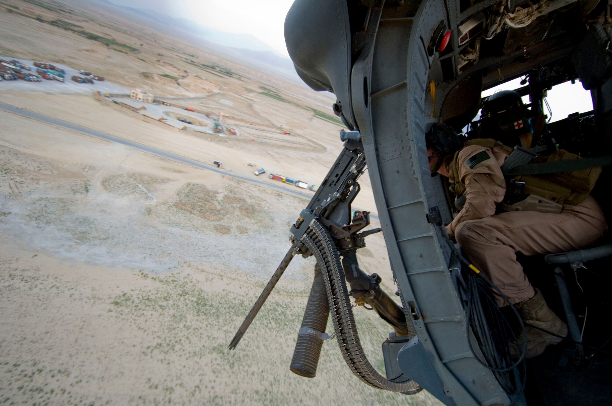 BAGRAM AIR FIELD, Afghanistan -- Senior Airman Ryan Ballinger, 33rd Expeditionary Rescue Squadron gunner, looks out at the ground below here on August 2, 2008. The strong main rotors, more than 54 feet in diameter, make steep turns like the one shown here possible. Airman Ballinger is deployed from the 33rd Rescue Squadron, Kadena Air Base, Japan. (U.S. Air Force photo by Staff Sgt. Samuel Morse)