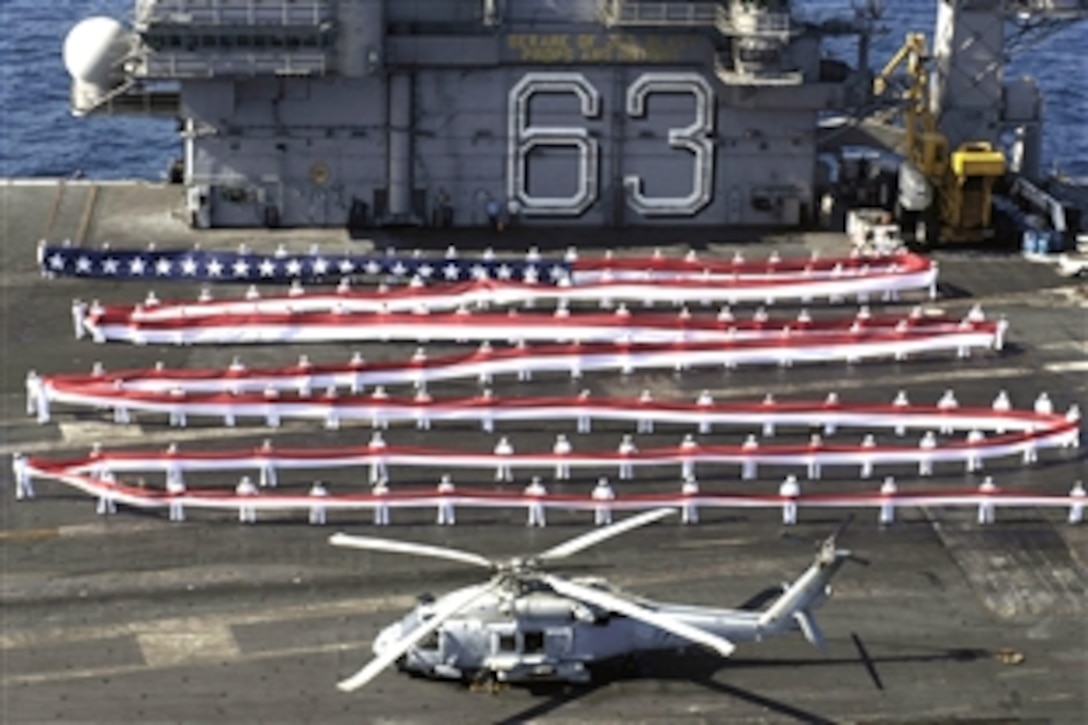 Two hundred fifty U.S. sailors on board USS Kitty Hawk display a 1,065-foot homecoming pennant on the flight deck as the ship approaches Naval Air Station North Island, Calif., Aug. 7, 2008, for the first time in 10 years. The USS Kitty Hawk is returning to San Diego, Calif., from Yokosuka, Japan, before its decommissioning ceremony scheduled in 2009. 
