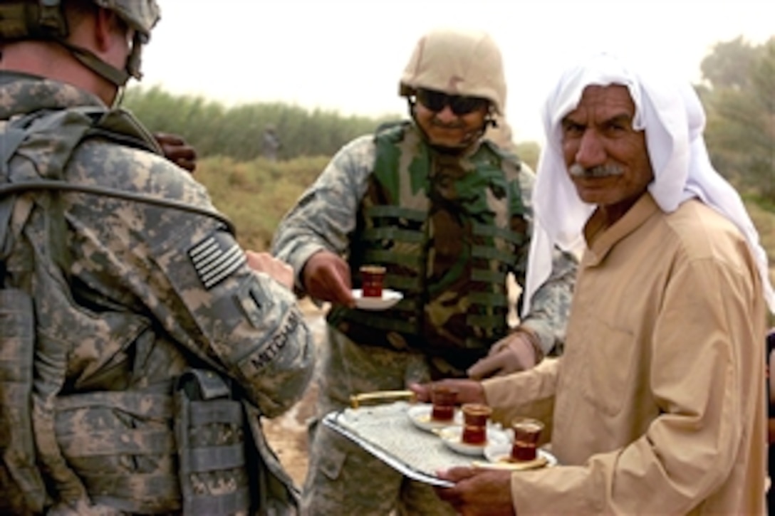 U.S. soldiers enjoy tea while talking with local residents during a patrol near Diyarah, Iraq,  Aug. 1, 2008. The gentleman serving tea gave the soldiers a brief history of the area, recalling a time when British troops occupied parts of Iraq. The soldiers listened to citizens’ concerns on many issues and gauged their feelings about local security forces.The troops are assigned to the 3rd Infantry Division's 1st Battalion, 76th Field Artillery Regiment.

