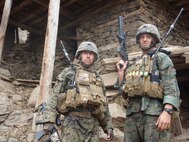 Staff Sgt.  Patrick Wire stands with his team leader, Gunnery Sgt. Hugo Tello, in the village of Chichal, Konar province, Afghanistan. Wire, currently the information systems management branch chief, was deployed to Afghanistan with an embedded training team in 2008, where he served as an instructor to Afghanistan National Army soldiers.