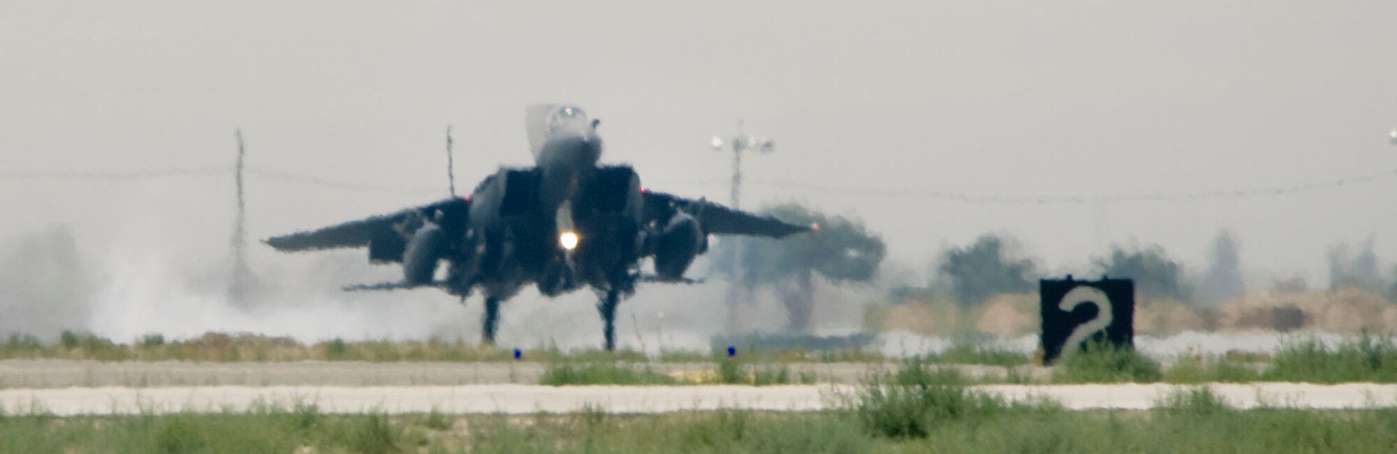 BAGRAM AIR FIELD, Afghanistan -- With a plume of smoke from the tires, an F-15E Strike Eagle lands here after a successful mission on August 1, 2008. Stress from heat an normal wear force maintenance crews to replace the F-15's tires more frequently than land-based vehicles. (U.S. Air Force photo by Staff Sgt. Samuel Morse)