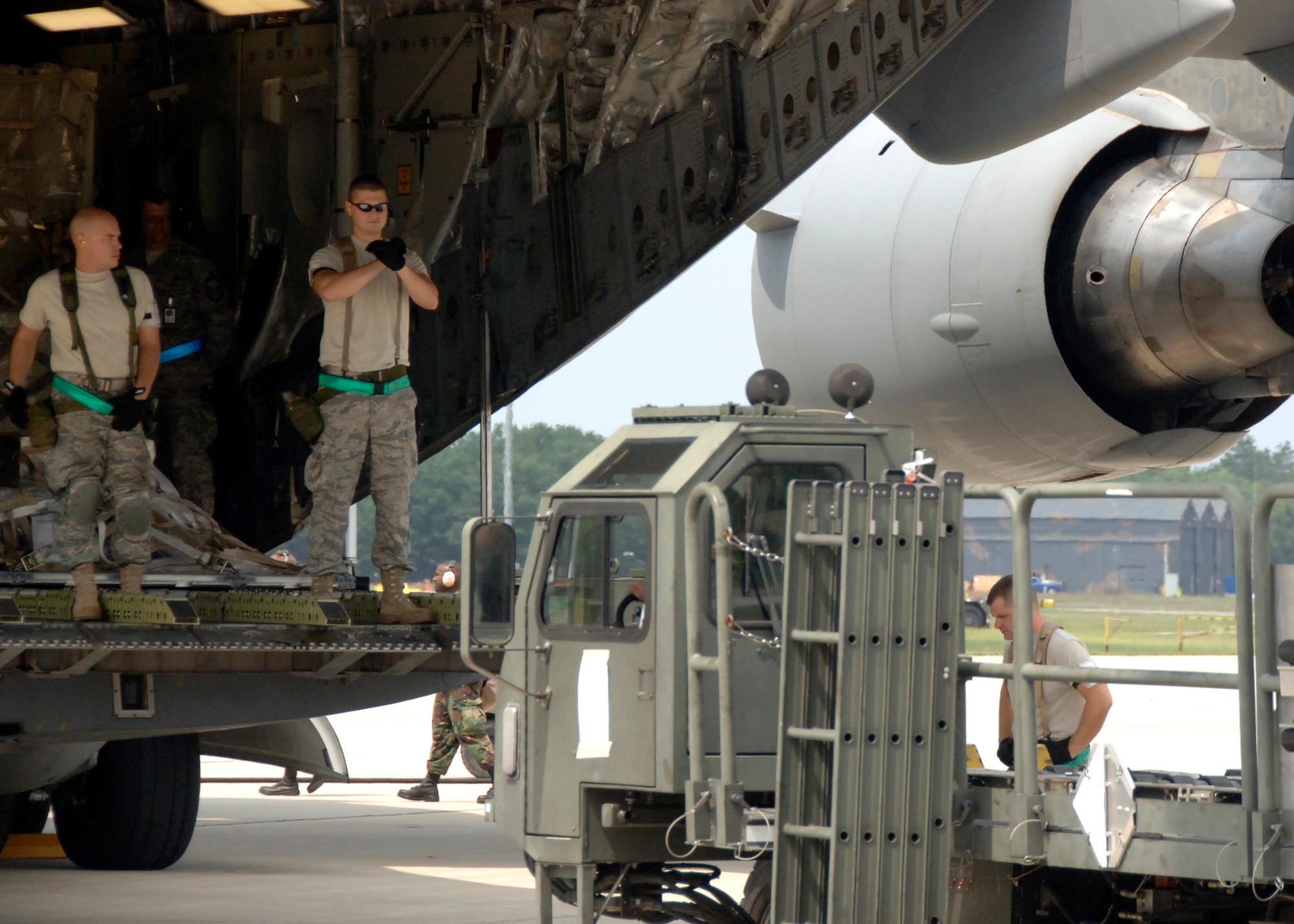 Airmen from the 437th Aerial Port Squadron guide a 60k tonner up to the back of a C-17 to unload supplies for the Operational Readiness Inspection at a simulated forward deployed location in Southeast Asia Aug. 7. Timely loading and unloading of planes on the flightline is one of the first steps to sucess for any operation. (U.S Air Force Photo/Airman 1st Class Timothy Taylor)