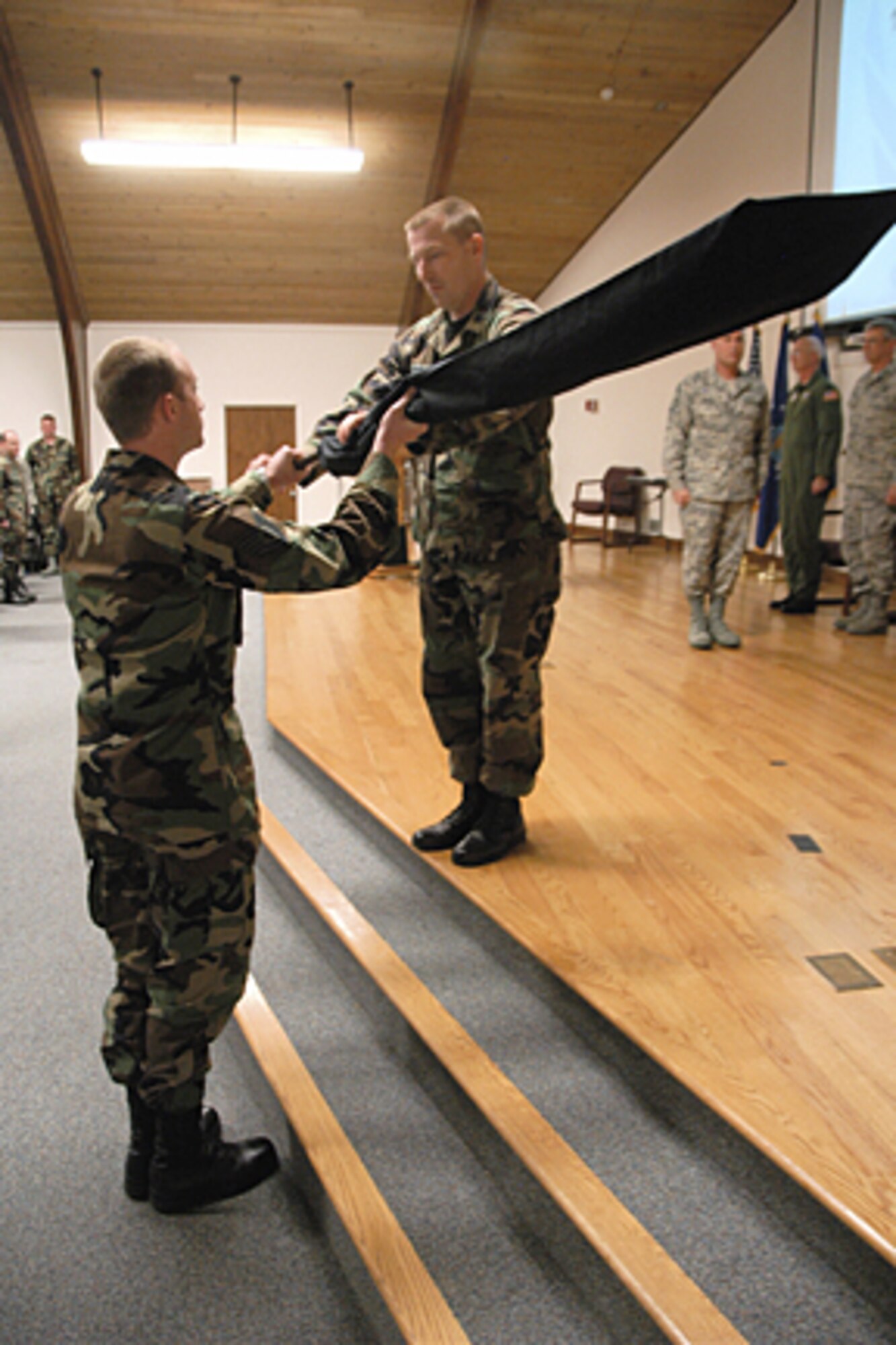 Lt. Col. Jeff Peters, commander of the 123rd Aerial Port Squadron, furls the unit’s colors one last time before casing the guide-on and handing it off for retirement during a deactivation ceremony held in the Base Annex on April 19. (Airman 1st Class Max Rechel/KyANG)

