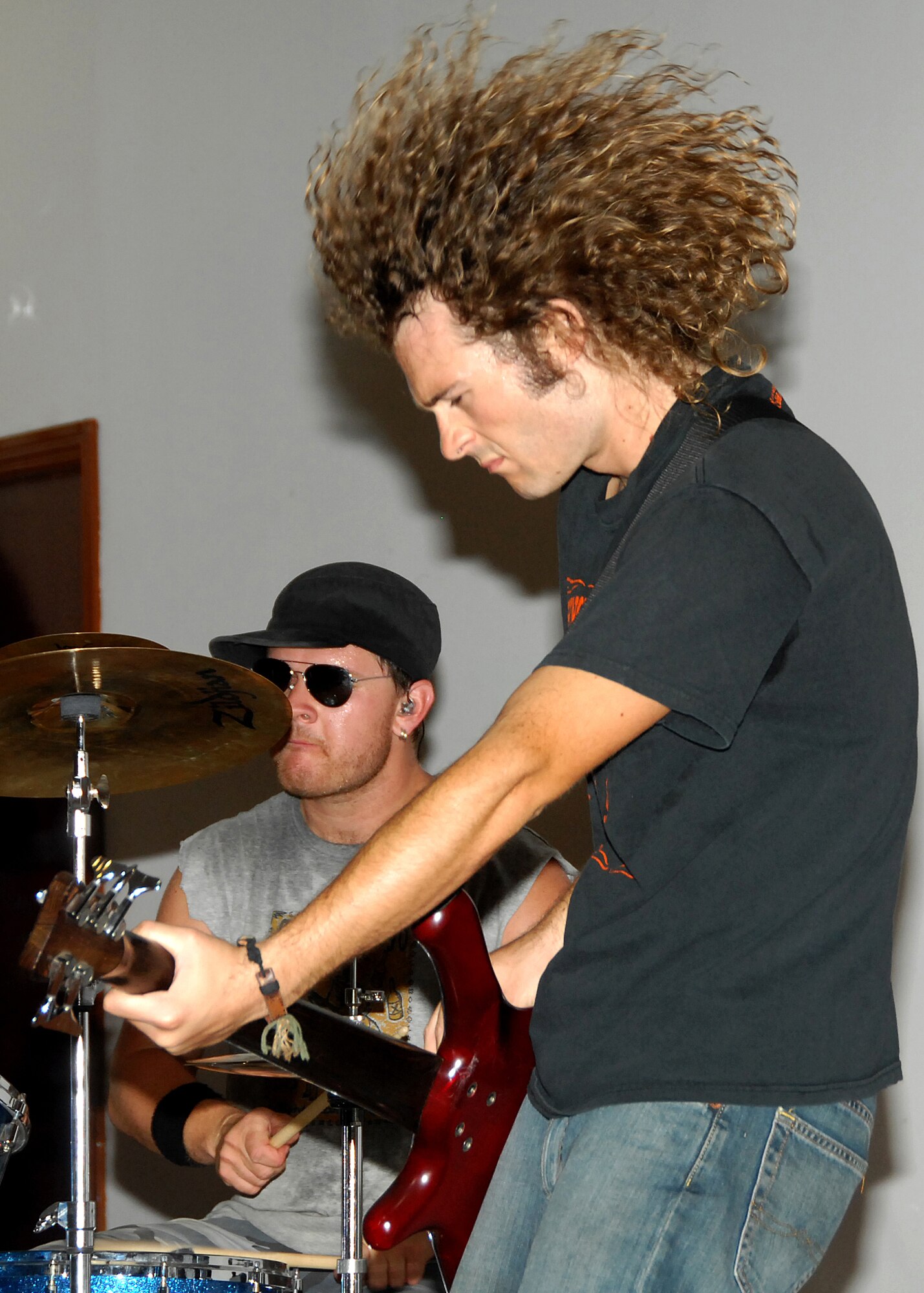SOUTHWEST ASIA -- Tony Glaser, bass guitarist for the band Beautiful Generation, puts on an energetic rock show on Aug. 8 at a base in Southwest Asia. This was the band?s first stop on their Operation Enduring Freedom Tour, which is sponsored by the United Service Organizations. The tour will take them to Iraq, Italy and Germany to entertain military members serving overseas. (U.S. Air Force photo/Tech. Sgt. Raheem Moore)
