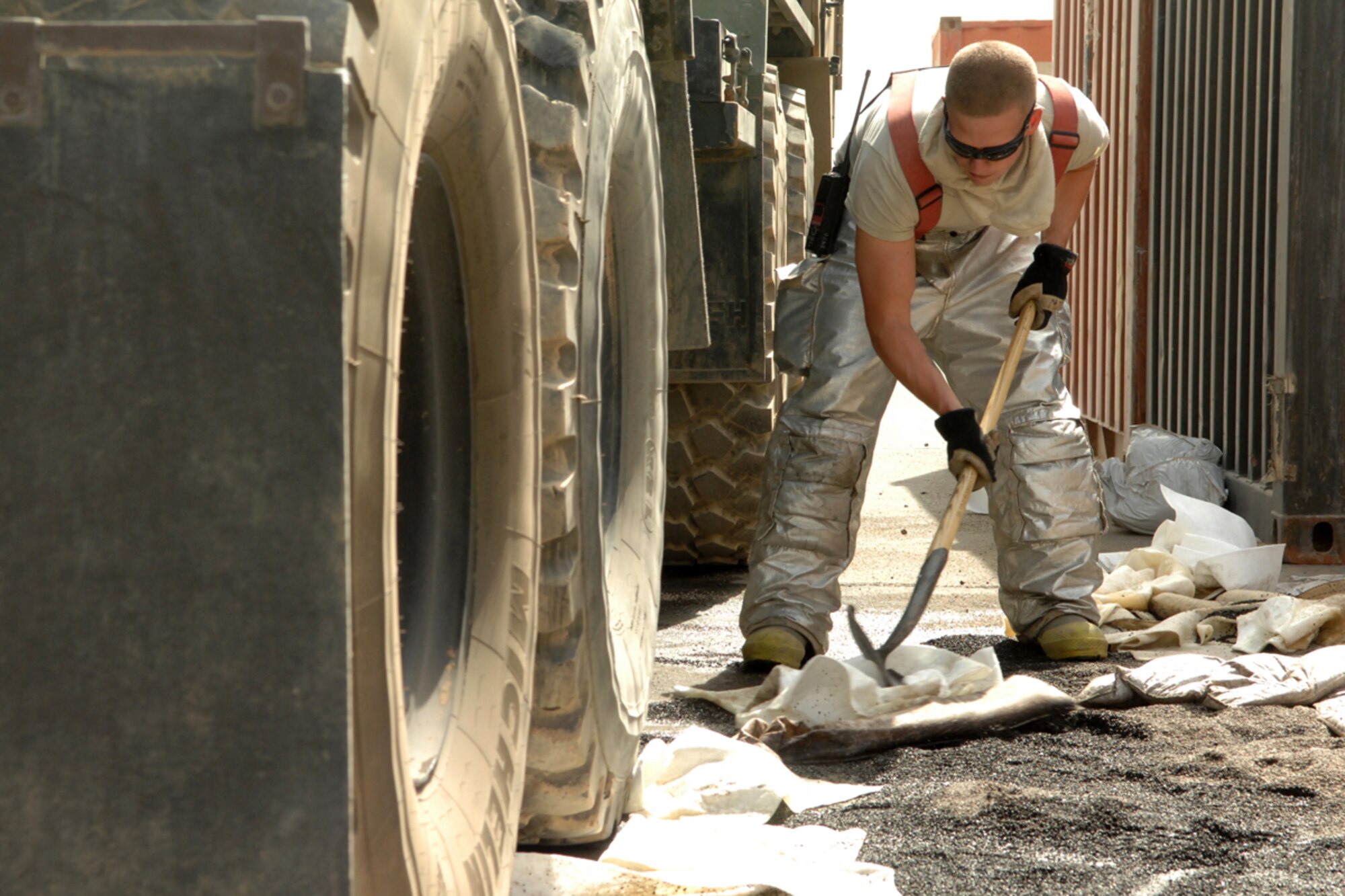 KIRKUK REGIONAL AIR BASE, Iraq -- Airman 1st Class Zackery Williams, 506th Expeditionary Civil Engineer Squadron firefighter, cleans up a fuel spill here Aug. 7.  Airman Williams was one of 10 firefighters responding to the spill which was cleaned up with no environmental impact occuring.  Airman Williams is deployed from Grand Forks, N.D., and calls Fort Mitchell, Ky., home. (U.S. Air Force photo/Senior Airman Randi Flaugh)