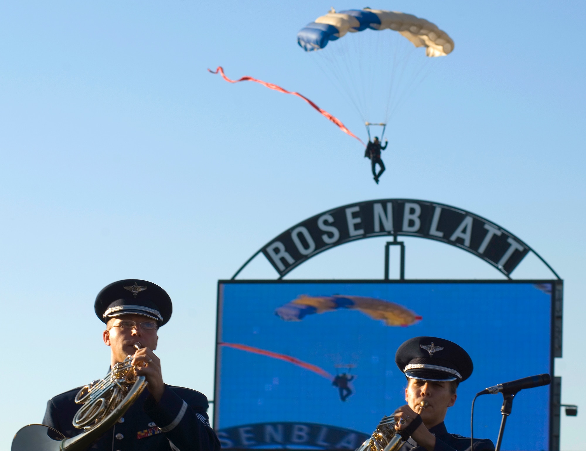 Members of the Heartland of America Band play while the U.S. Air Force Academy Wings of Blue jump team fly into Rosenblatt Stadium during opening ceremonies for Air Force Week in the Heartland Aug. 9 in Omaha, Neb. The week is designed to broaden awareness of the Air Force's role in the war on terrorism and strengthen support for Airmen serving worldwide in defense of freedom. (U.S. Air Force photo/Staff Sgt. Bennie J. Davis III)