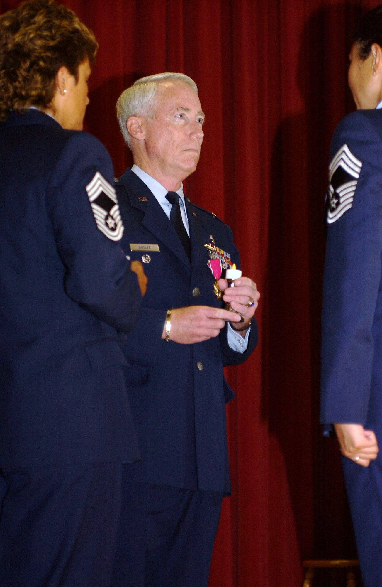 Col. Butler was invited to light a candle to signify his acceptance of the title of honorary chief master sergeant at his retirement ceremony, July 27. The candle is symbolic of the way honorary chiefs light the way for the enlisted force.(U.S. Air Force photo by Capt. Caroline Lorimer)