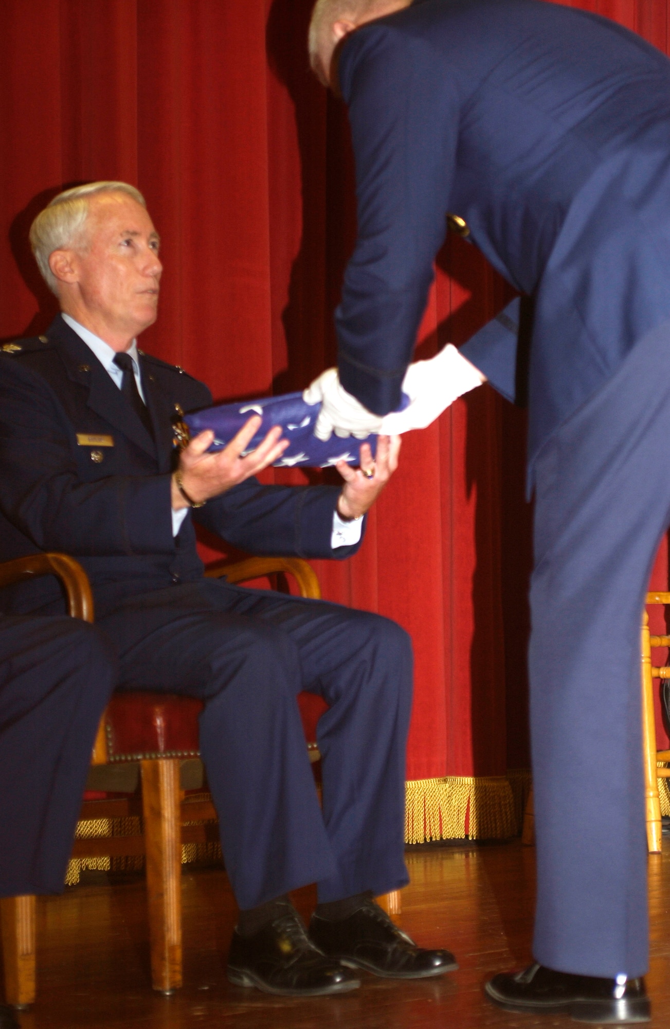 Col. Butler accepts a flag during his retirement ceremony. The flag had just been passed from the most junior airman to the most senior airman (U.S. Air Force photo by Capt. Caroline Lorimer)