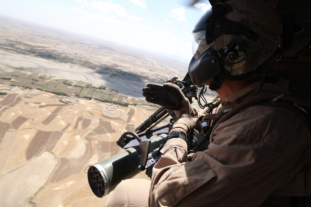 Staff Sgt. Jonathan Lee, a crew chief with Marine Light Attack Helicopter Squadron 369, 3rd Marine Aircraft Wing (Forward), explains what he's seeing to the pilots over radio communications during a combat assault support mission in southern Afghanistan July 16.
