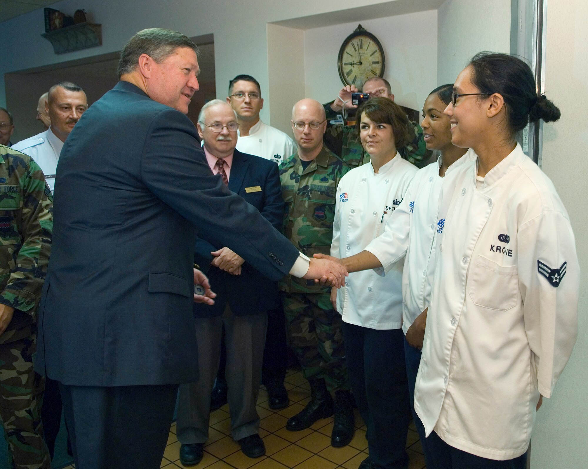 Acting Secretary of the Air Force Michael B. Donley presents Senior Airman Brandy Griffith and fellow members of the 55th Force Support Squadron with a coin for excellence in preparing a senior leadership breakfast Aug. 11 at the Ronald L. King Dining Facility at Offutt Air Force Base, Neb. (U.S. Air Force photo/Staff Sgt. Bennie J. Davis III)