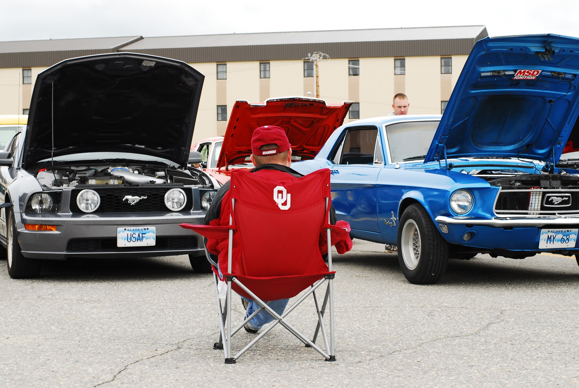 Tech. Sgt. Charley Helvy, 354th Logistics Readiness Squadron, sits back and relaxes in front of his two old and new generation Ford Mustangs during the second Iceman Car and Motorcycle Show sponsored by 354th Force Support Squadron Aug. 9, 2008, at Eielson Air Force Base, Alaska. Prizes were awarded for best motorcycle, best truck, and best current model vehicle and people's choice. (U.S. Air Force photo by Airman 1st Class Jonathan Snyder)