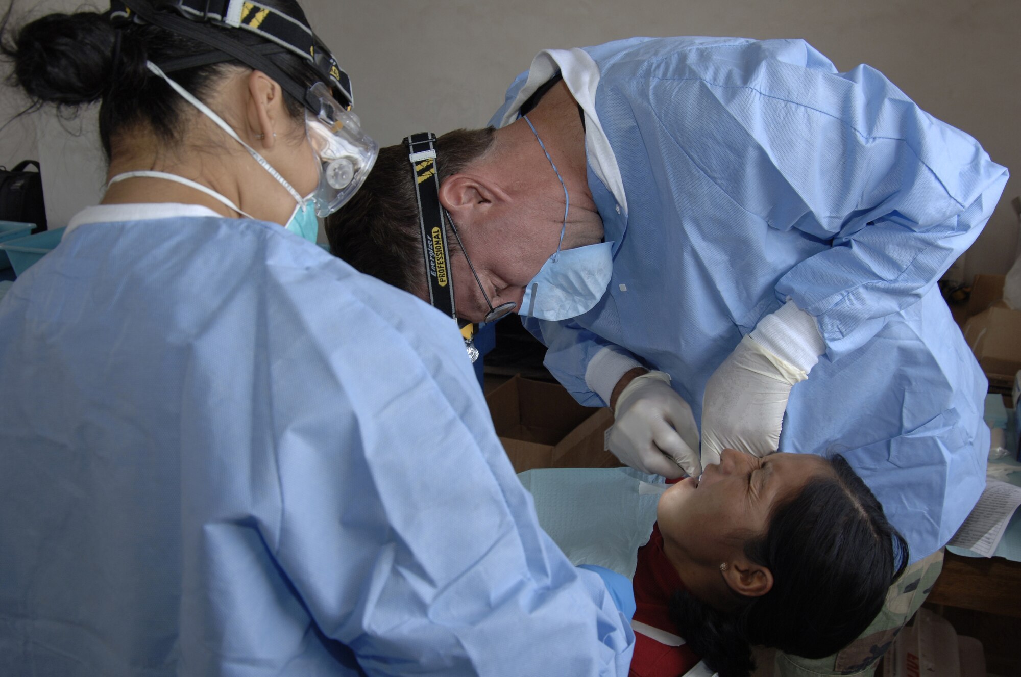 Lt. Col. (Dr.) Walter Weaver, right, and Senior Airman Betty Goldsmith, a dental technician, extract a tooth from a Peruvian woman during a medical mission in Mollepata, Peru, Aug. 1, 2008. (U.S. Air Force photo/1st Lt. Mary Pekas)