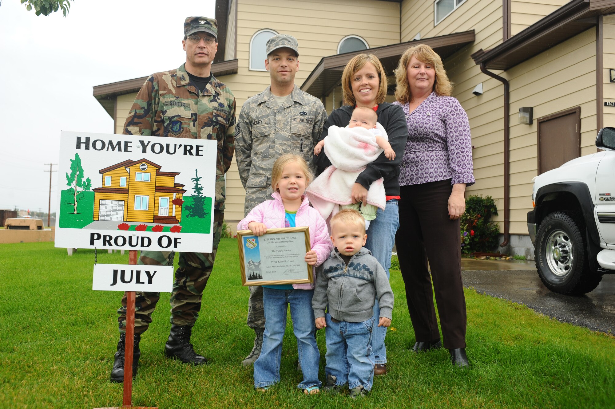 Tech. Sgt. Patrick Henry and his spouse, Molly, along with their children, display their Home You're Proud Of award with Col. John Stutts, 354th Mission Support Group commander, and Lorie Dallas, 354th CES military family housing, Aug. 8, 2008 at Eielson Air Force Base, Alaska. They won the HYPO award for the month of July; each winning household received $105 of gift cards from various units on base and businesses off base. (U.S. Air Force photo by Airman 1st Class Jonathan Snyder)