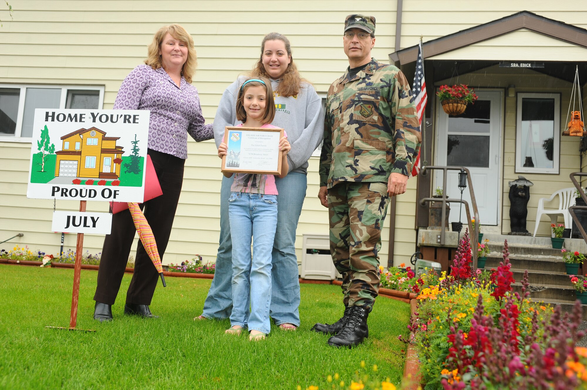 Nichole Edick, spouse of Senior Airman Dennis Edick, 354th Logistic Readiness Squadron, and their daughter display their Home You're Proud Of award with Col. John Stutts, 354th Mission Support Group commander, and Lorie Dallas, 354th CES military family housing, Aug. 8, 2008 at Eielson Air Force Base, Alaska. They won the HYPO award for the month of July; each winning household received $105 of gift cards from various units on base and businesses off base. (U.S. Air Force photo by Airman 1st Class Jonathan Snyder)