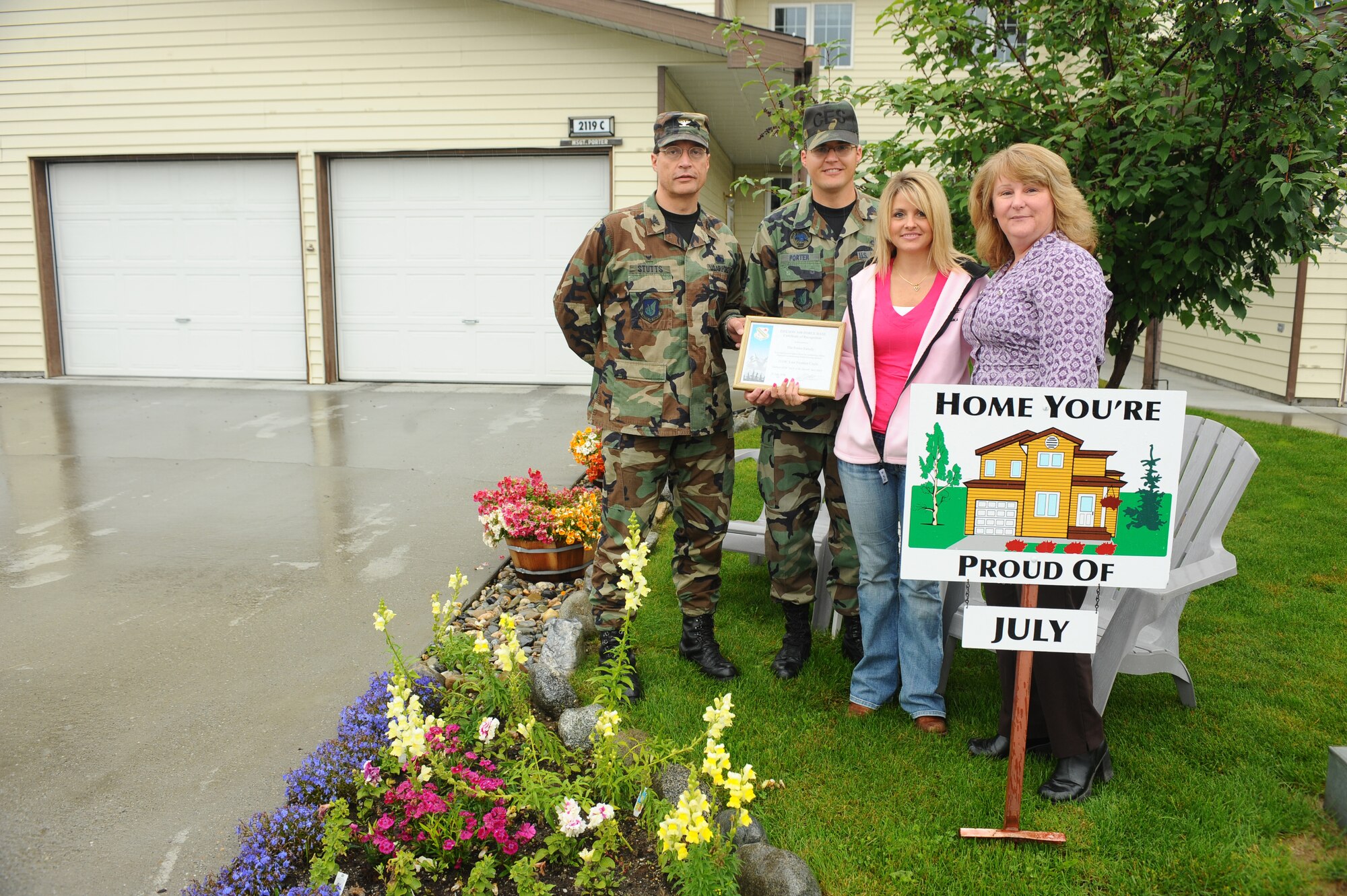 Master Sgt. Justin Porter, 354th Civil Engineer Squadron, and his spouse, Leanna, display their Home You're Proud Of award with Col. John Stutts, 354th Mission Support Group commander, and Lorie Dallas, 354th CES military family housing, Aug. 8, 2008, at Eielson Air Force Base, Alaska. They won the HYPO award for the month of July; each winning household received $105 of gift cards from various units on base and businesses off base. (U.S. Air Force photo by Airman 1st Class Jonathan Snyder)