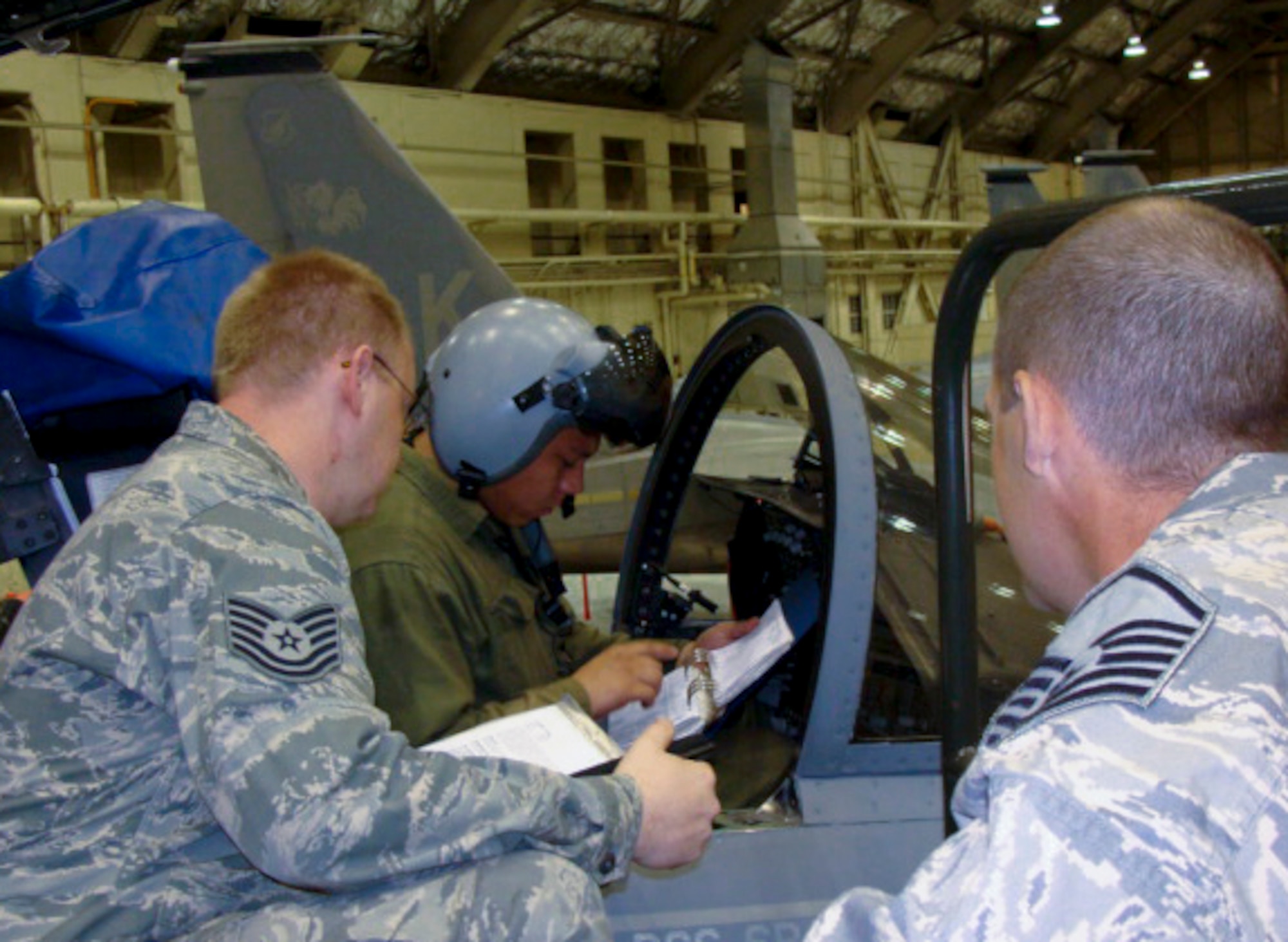 ELMENDORF AIR FORCE BASE, Alaska -- Master Sgt. Robert Teal and Tech. Sgt. Craig Farless perform a personal evaluation on Airman 1st Class Erik Garrett, 3rd Aircraft Maintenance Squadron, at Hangar 2. Sergeants Teal and Farless are members of the 3rd Maintenance Group. The Logistics Standardization and Evaluation Team will be inspecting the 3rd MXG Oct. 20-24. (U.S. Air Force photo)