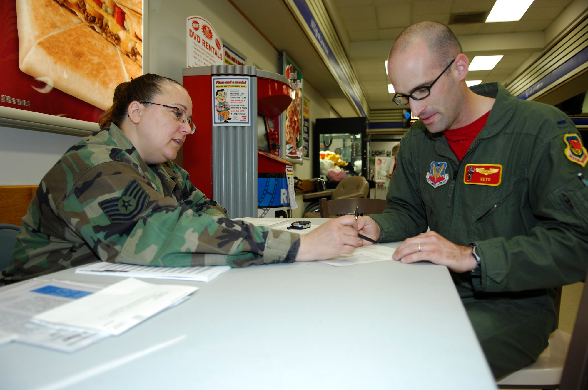 MINOT AIR FORCE BASE, N.D. – Tech. Sgt. Donna Bick, 5th Maintenance Squadron noncommissioned officer in charge of non-destructive inspection, gives absentee ballot instructions to 1st Lt. James Hoffman, 23rd Bomb Squadron navigator, at the voter registration booth in the Base Exchange here Aug. 8. Sergeant Bick volunteered her time to act as the 5th MXS voting representative, as well as work at the registration booth supporting the base-wide voter registration drive held Aug. 4 to 8. (U.S. Air Force photo by Staff Sgt. Thomas Dow)
