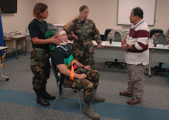 MOODY AIR FORCE BASE, Ga. – Tech. Sgt. Charity Gerner, 23rd Aerospace Medical Squadron NCO in-charge of ambulance dispatch, explains to Mark Soliz, 23rd Medical Group education manager, how to transfer a victim from a Kendrick extraction device to a spine board here Aug. 6. Mr. Soliz has emergency medical technicians take a refresher course to make sure their up-to-speed on basic medical skills. (U.S. Air Force photo by Airman Joshua Green) 