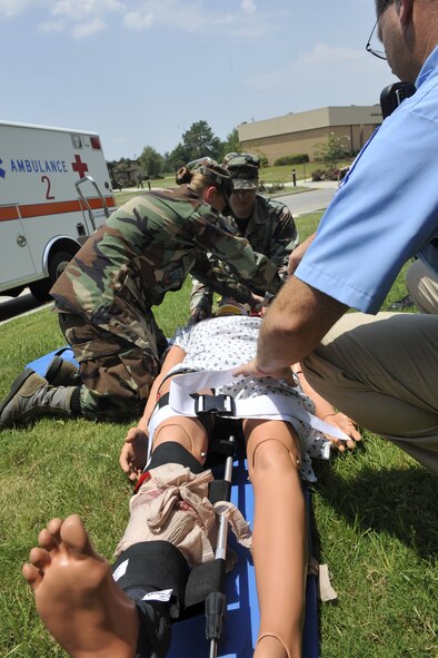 MOODY AIR FORCE BASE, Ga. -- 23rd Medical Group emergency medical technicians practice securing a mannequin on a spine board, while providing medical attention here Aug. 7. The mannequin was used to simulate a victim who fell down from a building during a patient trauma assessment. (U.S. Air Force photo by Senior Airman Schelli Jones)