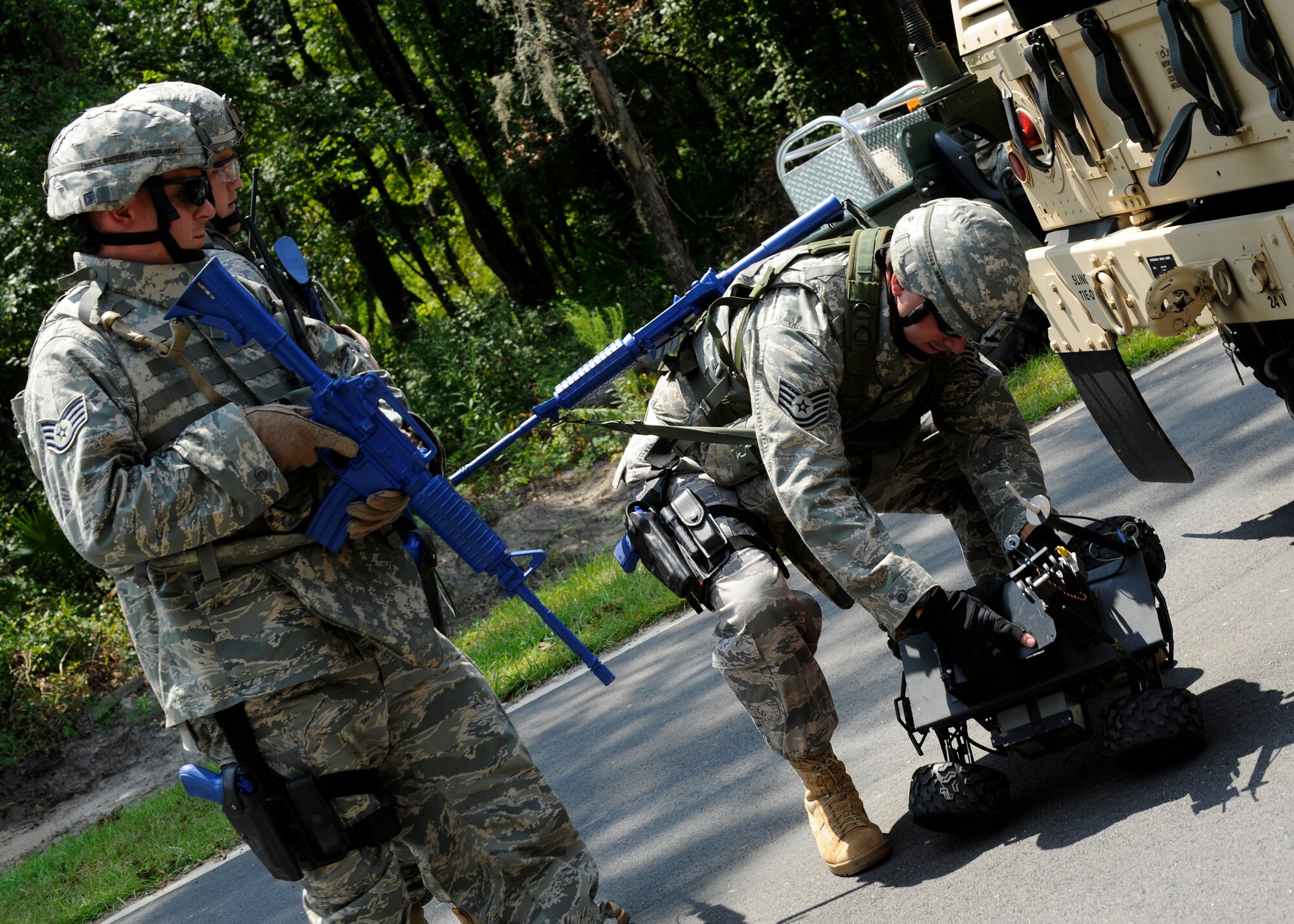 MOODY AIR FORCE BASE, Ga. -- Tech. Sgt. Jason Somers, 823rd Security Forces Squadron, activates a test phase wheeled robot while Staff Sgts. Jeremiah Dupriest and Gary Hilliard prepare to watch the monitor screen of the robot’s view during an improvised explosive device sweep training exercise here July 25. The 823rd SFS members are participated in IED sweep training to increase readiness for future deployments. (U.S. Air Force photo by Airman 1st Class Brittany Barker)