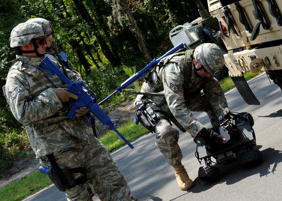 MOODY AIR FORCE BASE, Ga. -- Tech. Sgt. Jason Somers, 823rd Security Forces Squadron, activates a test phase wheeled robot while Staff Sgts. Jeremiah Dupriest and Gary Hilliard prepare to watch the monitor screen of the robot’s view during an improvised explosive device sweep training exercise here July 25. (U.S. Air Force photo by Airman 1st Class Brittany Barker)