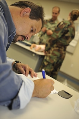 MOODY AIR FORCE BASE, Ga. -- Mark Soliz, 23rd Medical Group education manager, writes a comment on an evaluation form during a medical assessment here Aug. 7.  The assessment is part of an annual emergency medical technician refresher course, held in August and November. (U.S. Air Force photo by Senior Airman Schelli Jones)