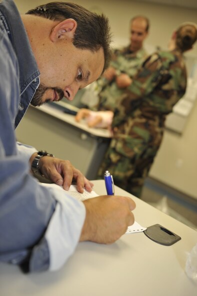 MOODY AIR FORCE BASE, Ga. -- Mark Soliz, 23rd Medical Group education manager, writes a comment on an evaluation form during a medical assessment here Aug. 7.  The assessment is part of an annual emergency medical technician refresher course, held in August and November. (U.S. Air Force photo by Senior Airman Schelli Jones)