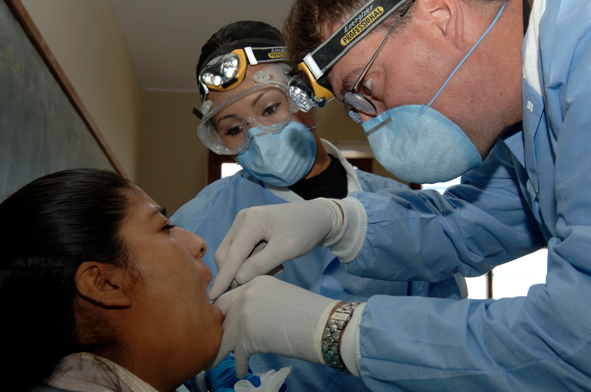 Dr. (Lt. Col.) Walter Weaver, a dentist with Task Force New Horizons, left, and Senior Airman Betty Goldsmith, a dental technician, perform a tooth extraction on a Peruvian woman during a medical mission in Quinua, Peru, Aug. 7.  The team of 19 medical professionals from the 433rd Medical Group at Lackland AFB, Texas, deployed to Peru to support three medical exercises supporting New Horizons - Peru 2008, a partnered U.S. and Peruvian humanitarian effort to bring quality-of-life projects to the people of Ayacucho, Peru. (U.S. Air Force photo/1st Lt. Mary Pekas)