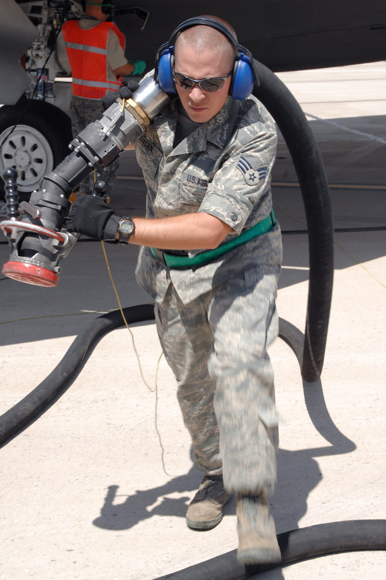 Senior Airman Kurtis Toycen, a fuels specialist with the 49th Logistics Readiness Squadron at Holloman Air Force Base, N.M., secures a refueling hose July 23, while Tech. Sgt. Aaron Cowan, a maintainer with the 49th Aircraft Maintenance Squadron, locks the fuel receptacle on an F-22 Raptor.  The team successfully refueled the aircraft while its engines were still running, a procedure called "hot refueling."  (U.S. Air Force photo/Airman 1st Class Jamal D. Sutter)