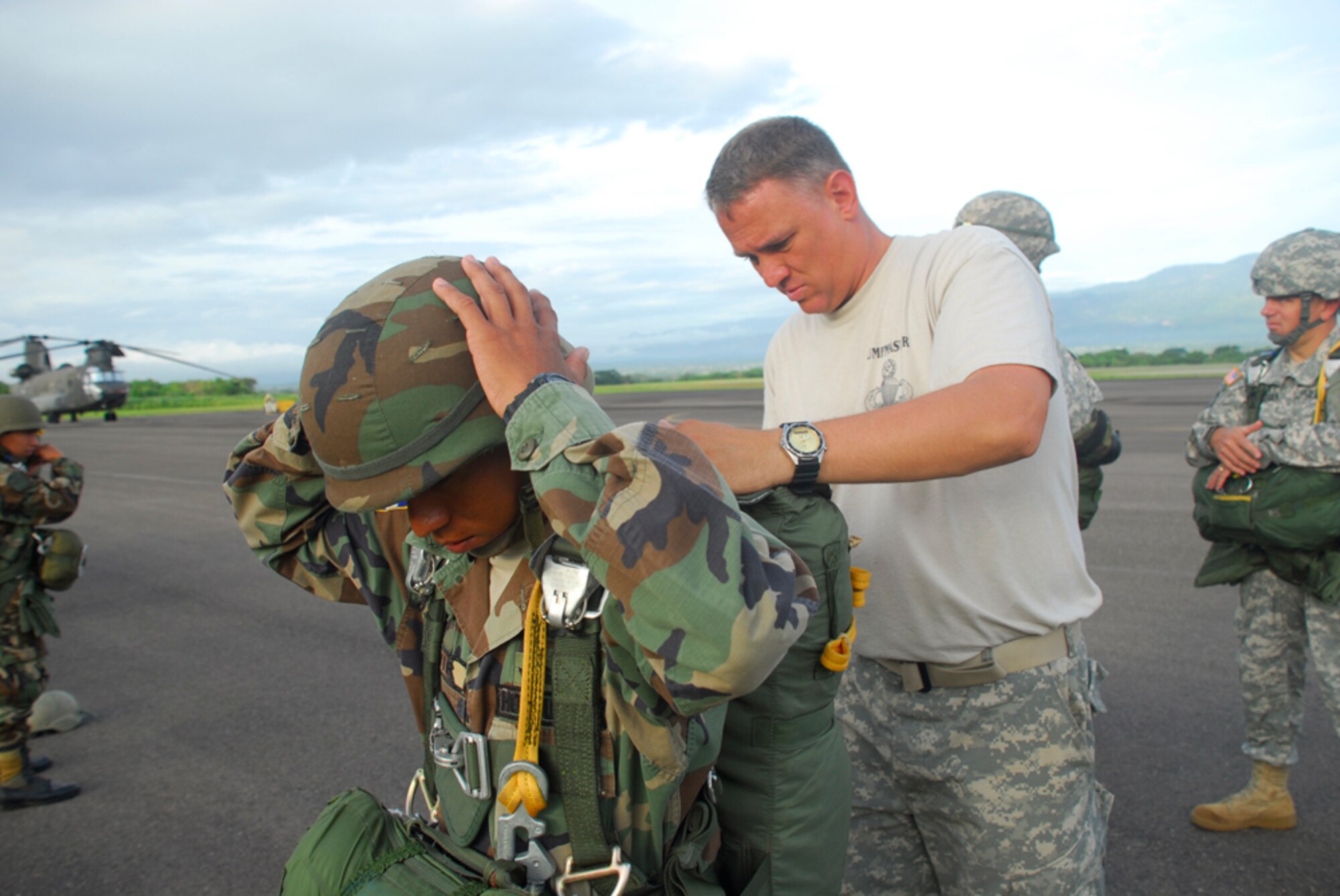 SOTO CANO AIR BASE, Honduras -- Army Staff Sgt. David Hattan, Joint Task Force-Bravo Rigger NCOIC, looks over the parachute of a Honduran Air Force servicemember Aug. 8. Sergeant Hattan is one of only two Army riggers stationed here. (U.S. Air Force photo by Staff Sgt. Joel Mease)