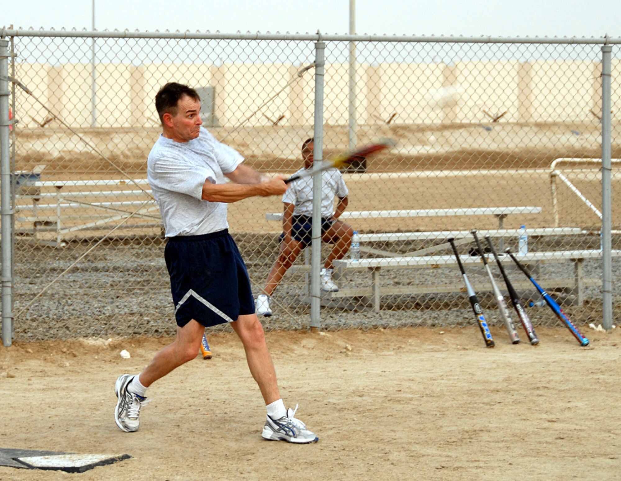 SOUTHWEST ASIA -- Over 40 second baseman and 380th Air Expeditionary Wing commander, Brig. Gen. H.D. Polumbo, Jr., smacks one up the middle for a base hit Wednesday. The Over 40 team moved into the next bracket of the tournament after defeating the Wing Staff Agency, 24-14. The nicknamed “Geriatrics” are the favorites to win. (U..S. Air Force photo/Tech. Sgt. Denise Johnson)(released)