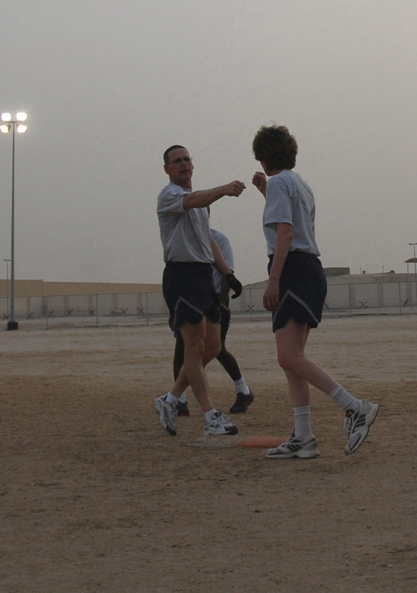 SOUTHWEST ASIA -- Chief Karen De Jong, Over 40 base coach, gives Command Chief Slater props after he lands a single. (U.S. Air Force photo/Tech. Sgt. Denise Johnson)(released)