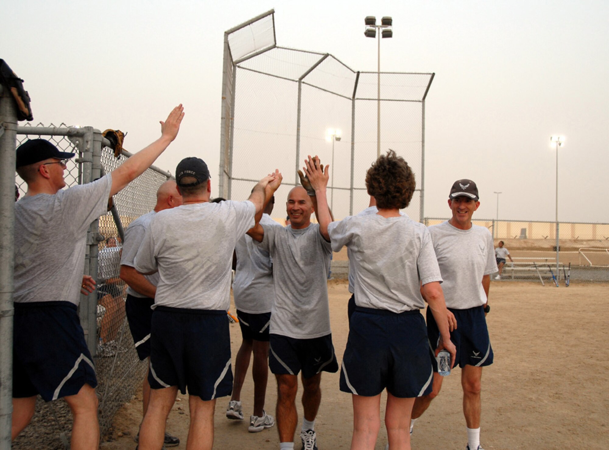 SOUTHWEST ASIA -- Left fielder, Chief Kevin Shavnore, is greeted at the dugout with high-fives and cheers from Over 40 teammates after an in-the-park homerun Wednesday. The game was a decided win over WSA, 24-14. (U.S. Air Force photo/Tech. Sgt. Denise Johnson)(released)
                            