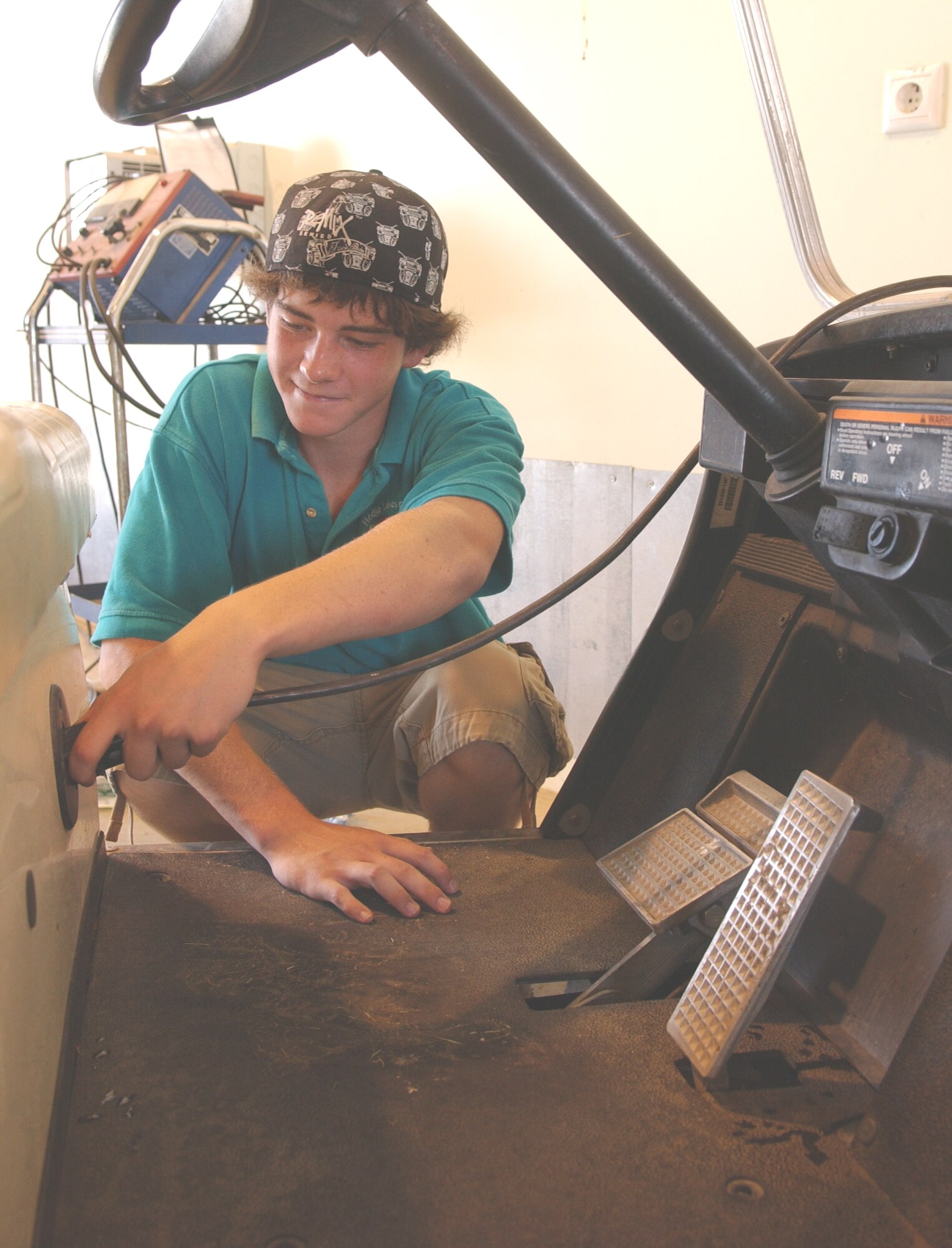 Tyeler Barker, 16, hooks up a golf cart to charge at the Hodja Lake Golf Course. Tyeler participates in the Summer Hire Program where dependents get work experience at various base locations during the summer.(U.S. Air Force photo by Airman 1st Class Amber Russell)