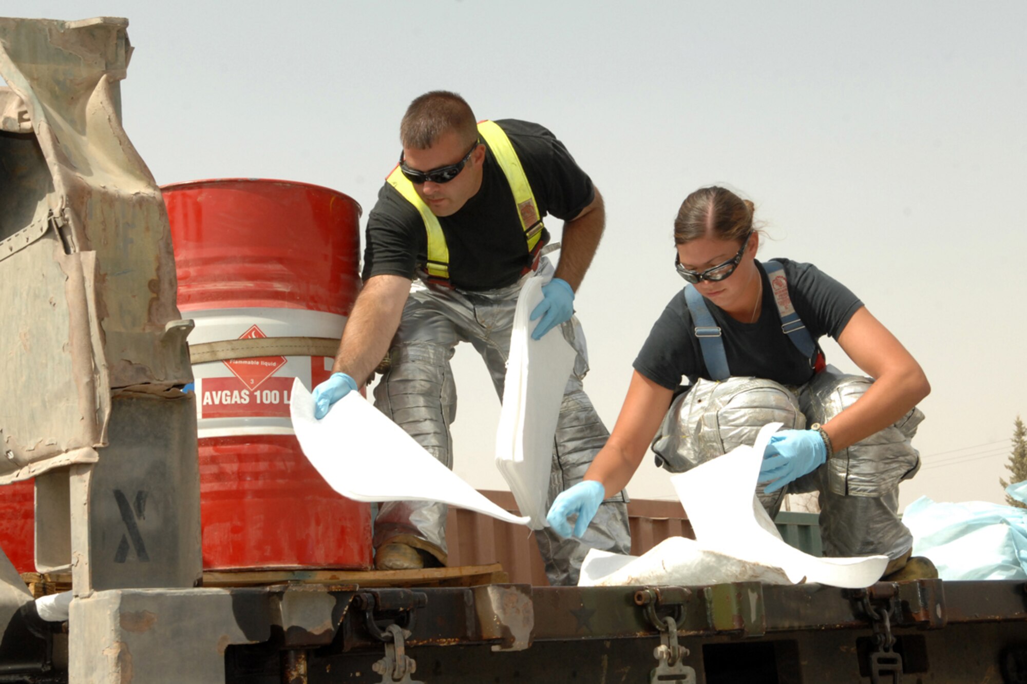 KIRKUK REGIONAL AIR BASE, Iraq -- Staff Sgt. Rodney Lower and Senior Airman Crystal Molinary, 506th Expeditionary Civil Engineer Squadron firefighters, clean up a fuel spill here Aug 7.  They were two of 10 firefighters responding to the spill which was cleaned up with no environmental impact.  Both are deployed from Spangdahlem Air Base, Germany. (U.S. Air Force photo/Senior Airman Randi Flaugh)