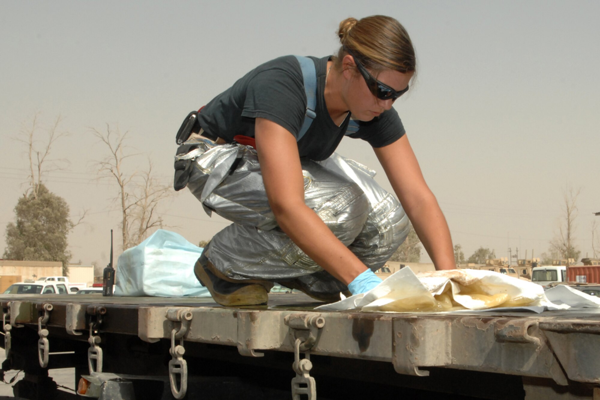 KIRKUK REGIONAL AIR BASE, Iraq -- Senior Airman Crystal Molinary, 506th Expeditionary Civil Engineer Squadron firefighter, cleans up a fuel spill here Aug 7.  Airman Molinary was one of 10 firefighters responding to the spill which was cleaned up with no environmental impact.  She is deployed from Spangdahlem Air Base, Germany, and calls Gettysburg, Pa., home. (U.S. Air Force photo/Senior Airman Randi Flaugh)