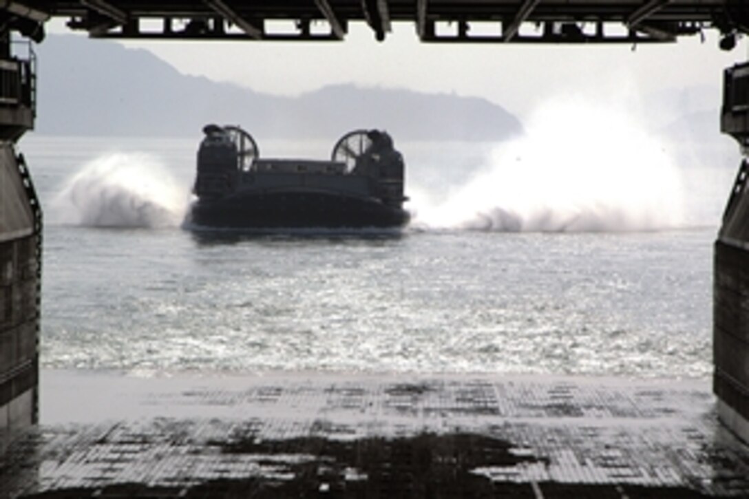 The crew of a Landing Craft Air Cushion prepares to pull into the well deck of the forward-deployed amphibious assault ship USS Essex during Gator Cruise 2008 in the Pacific Ocean, Aug. 7, 2008. A Gator Cruise is an invitation for sailors to bring friends and family members aboard to let them experience life at sea.  