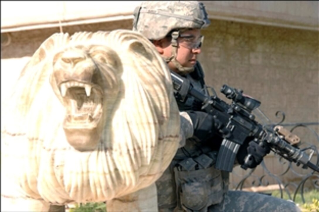 A U.S. Army soldier provides security at the entrance to the Baghdad Zoo, Aug. 8, 2008, during the arrival of two new tigers donated by the Conservators' Center in North Carolina. The soldiers are assigned to the 4th Infantry Division's Battery B, 4th Battalion, 42nd Field Artillery, 1st Brigade Combat Team.  
                            
