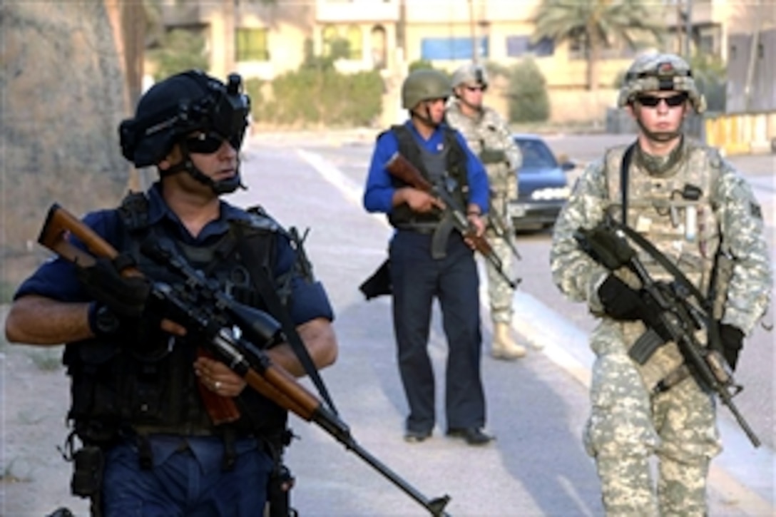 U.S. Army Spc. Daniel Clifford, front right, provides security during a combined patrol with Iraqi police in the Ha'Teen district of Baghdad, Iraq, Aug. 4, 2008. Clifford is a medic assigned to the 4th Infantry Division's 4th Battalion, 42nd Field Artillery, 1st Brigade Combat Team.                  
