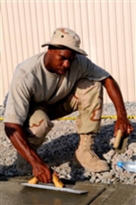 U.S. Air Force Staff Sgt. Eric Wilson finishes a sidewalk leading to a dining facility at Manas Air Base, Kyrgyz Republic, on Aug. 8, 2008.  Wilson is assigned to the 376th Expeditionary Civil Engineer Squadron.  