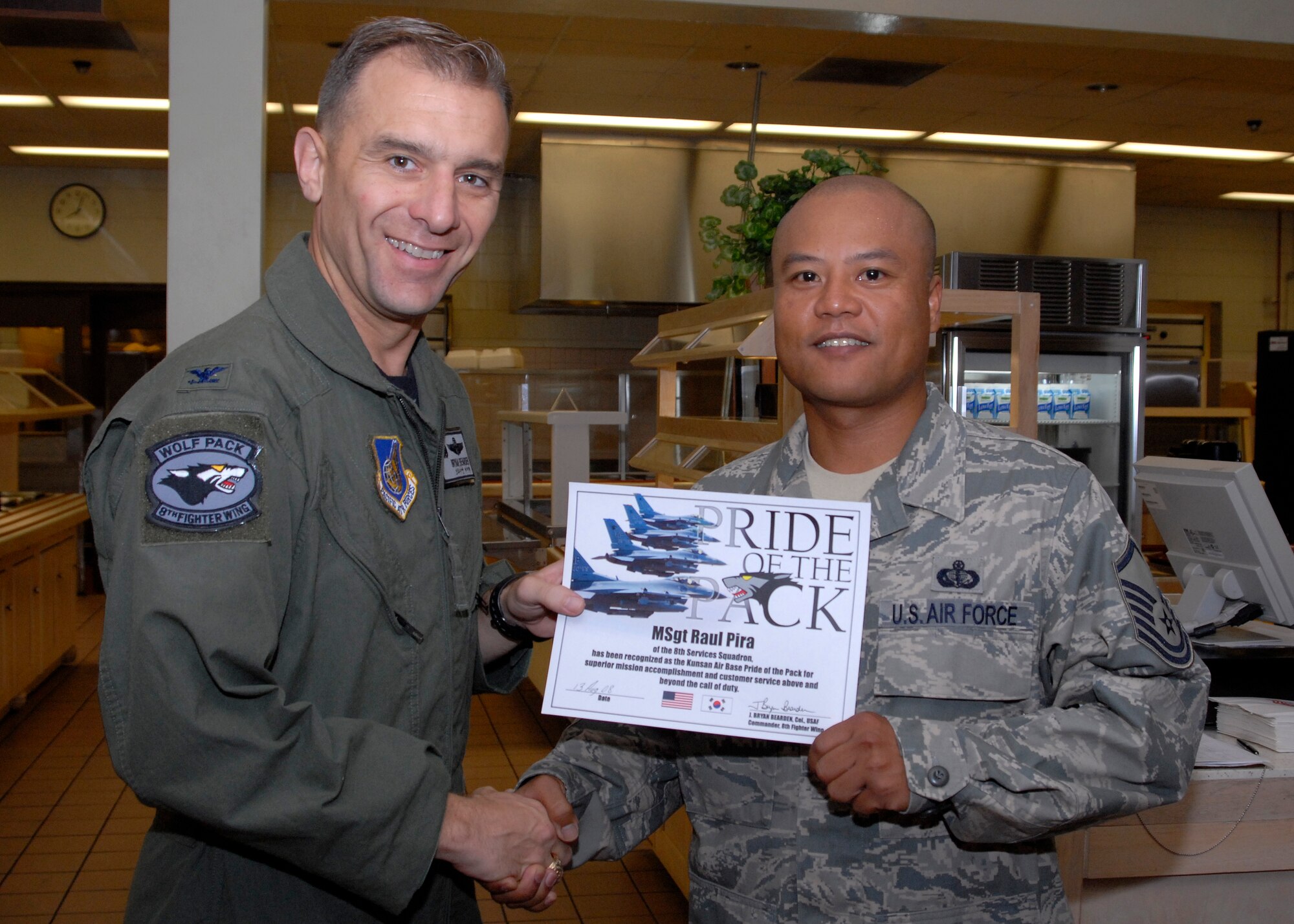 KUNSAN AIR BASE, Republic of Korea? Colonel Bryan Bearden,8th Fighter Wing Commander, presents Master Sergeant Raul Pira, Food Services chief,  8th Force Support Squadron, with Pride of the pack here August 13. (US Air Force Photo By: Senior Airman Angela Ruiz)
