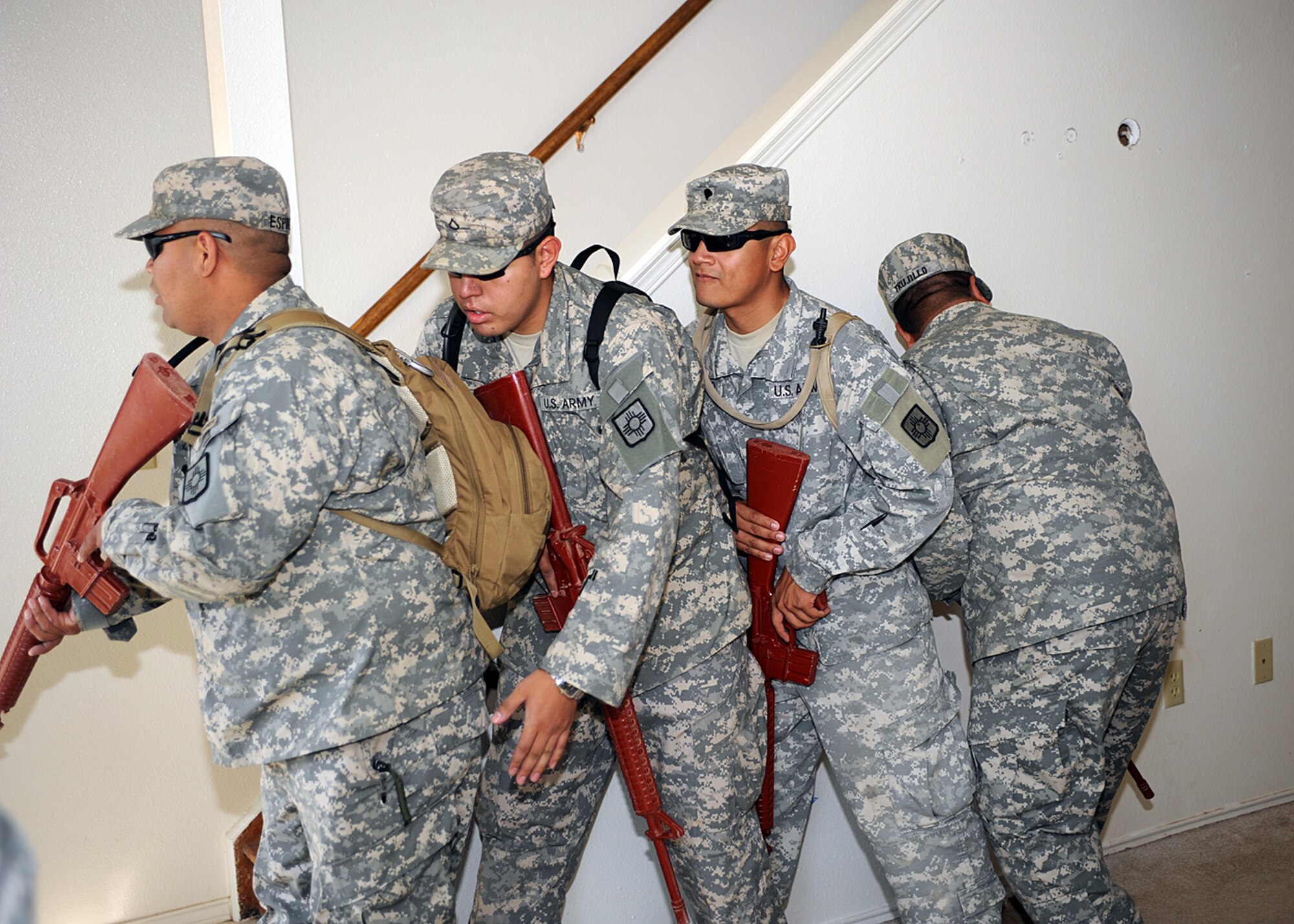 The Army National Guard, based out of Roswell and Alamogordo, N.M., prepare to go up steps in an old base housing unit during a clearing exercise at Holloman Air Force Base, N.M. The unit is preparing for upcoming live fire training and a pending deployment. (U.S Air Force photo/ Airman 1st Class DeAndre Curtiss) 