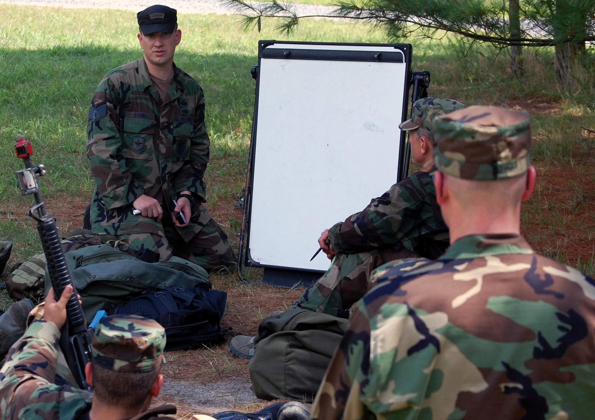 Staff Sgt. Paul Evans, 421st Combat Training Squadron, talks to students in the Advanced Contingency Skills Training Course about their progress for the day in patrolling and tactics training for the course Aug. 12, 2008, on a range on Fort Dix, N.J.  The course, taught by the U.S. Air Force Expeditionary Center's 421st CTS, prepares Airmen from multiple career fields for upcoming deployments.  (U.S. Air Force Photo/Tech. Sgt. Scott T. Sturkol)