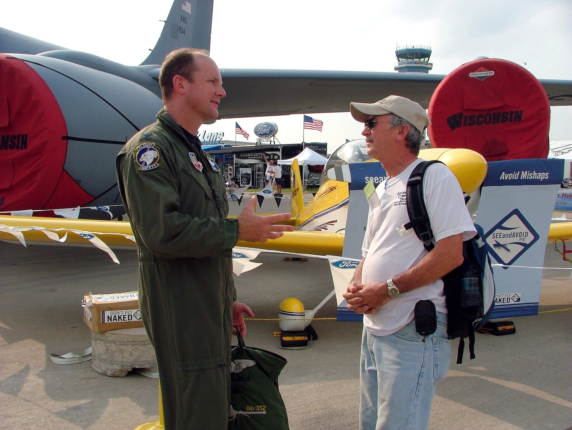 Lt. Col. Ned Linch, the 12th Air Force (Air Forces Southern) chief of flight safety, meets with a civilian pilot during the Experimental Aircraft Association's Oshkosh Air Venture airshow in Oshkosh, Wis., where more than 540,000 civilian and military pilots from around the globe gathered July 31 through Aug. 3. The colonel was attending the airshow to educate general aviation and civilian pilots on midair collision avoidance and on the need for flight safety and planning awareness.  (U.S. Air Force photo/Tech. Sgt. Kerry Jackson)