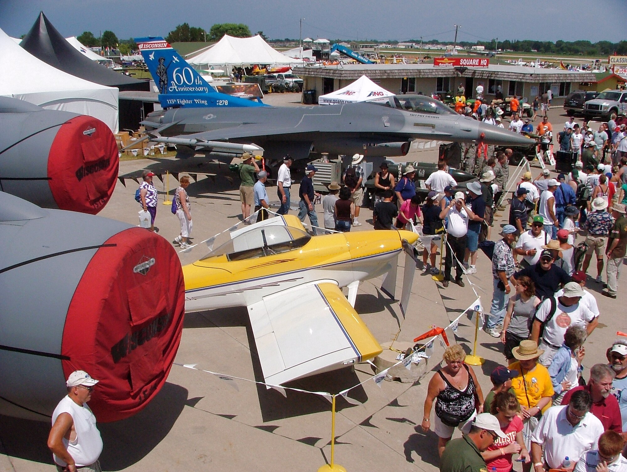 An F-16 Fighting Falcon, as well as six other Air Force aircraft, is on display at the Experimental Aircraft Association's Oshkosh Air Venture airshow in Oshkosh, Wis.  More than 540,000 civilians and military pilots from around the globe gathered July 31 through Aug. 3 for the event.  The yellow and white aircraft sitting beside the F-16 is a home-built experimental RV-4.  (U.S. Air Force photo/Tech. Sgt. Kerry Jackson)