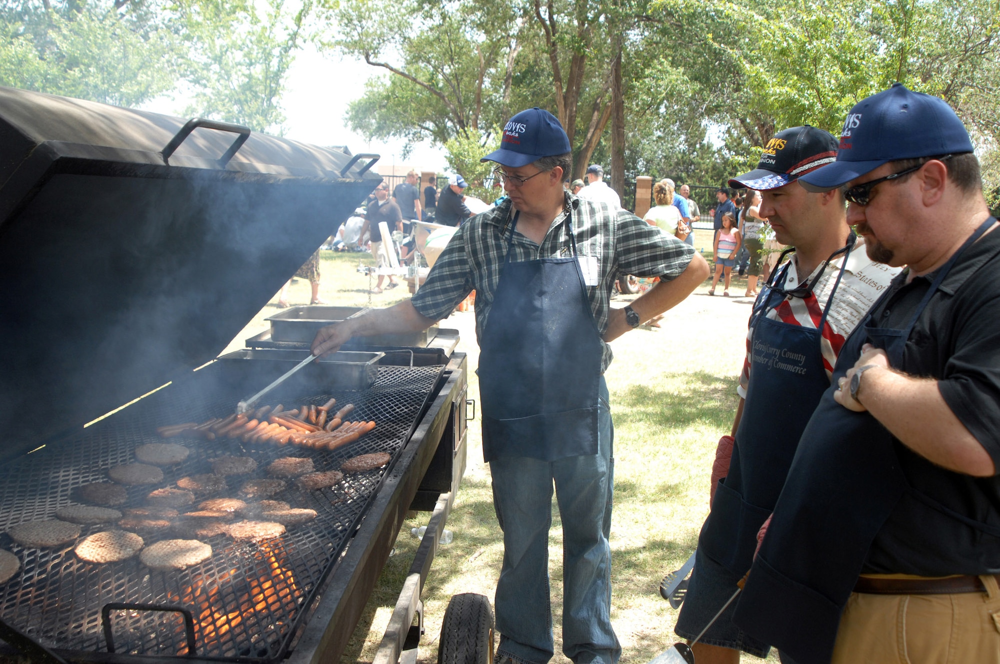 CANNON AIR FORCE BASE, N.M. - (From the rear to the front) Lance Adkins, Craig Scott and Randy Petty keep the 'burgers and 'dawgs cooking during the 19th Annual Cannon Appreciation Day Aug. 8. Along with free food and drink, Clovis, N.M. civic leaders and business gave away nearly $5,000 in prizes. (U.S. Air Force photo by Greg Allen)