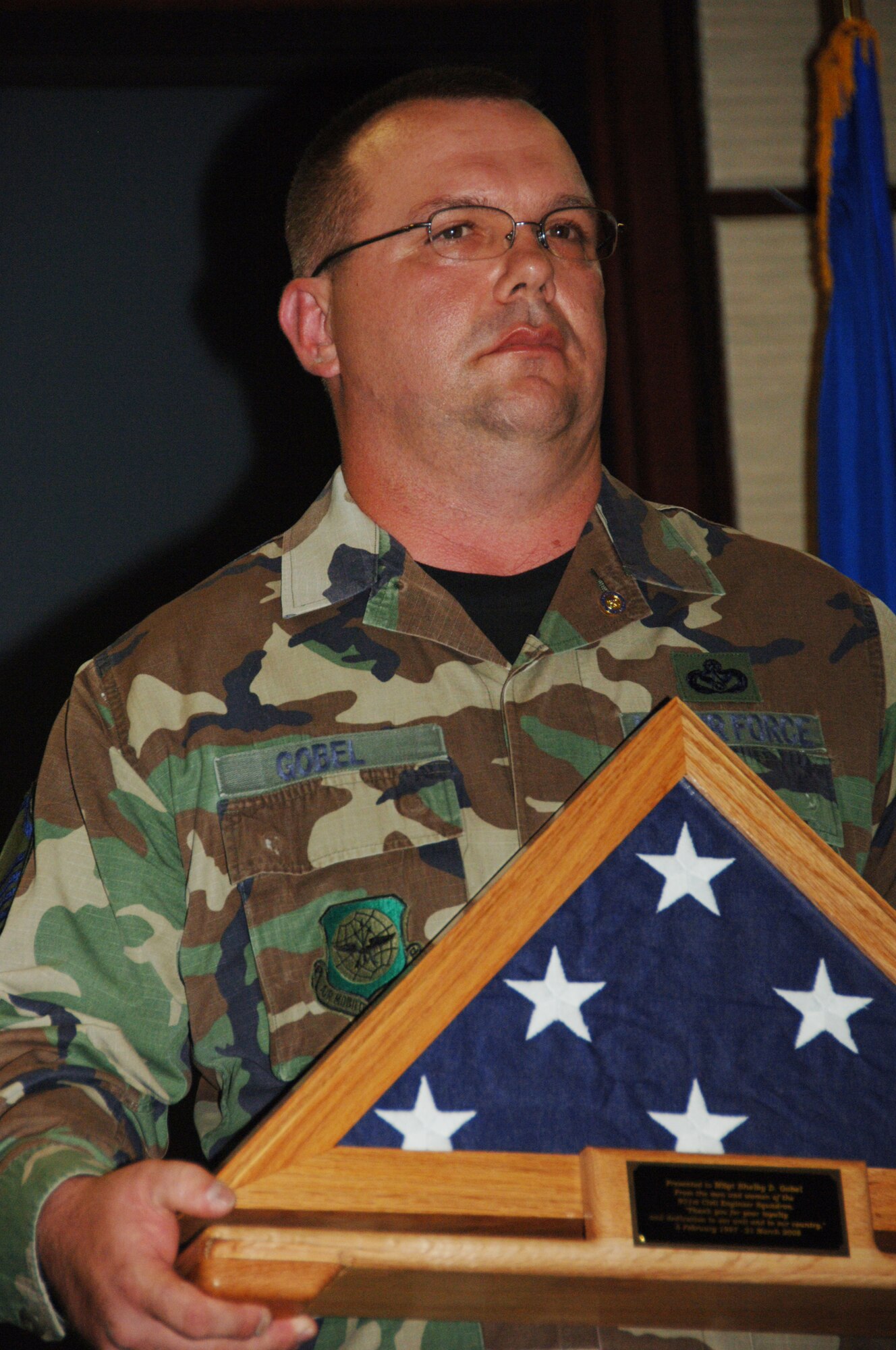 Master Sgt. Shelby Gobel holds the flag given to him during his retirement ceremony on Aug. 9.  Sergeant Gobel retired from the 931st Civil Engineer Squadron two years after he collided with a deer while riding a motorcycle.