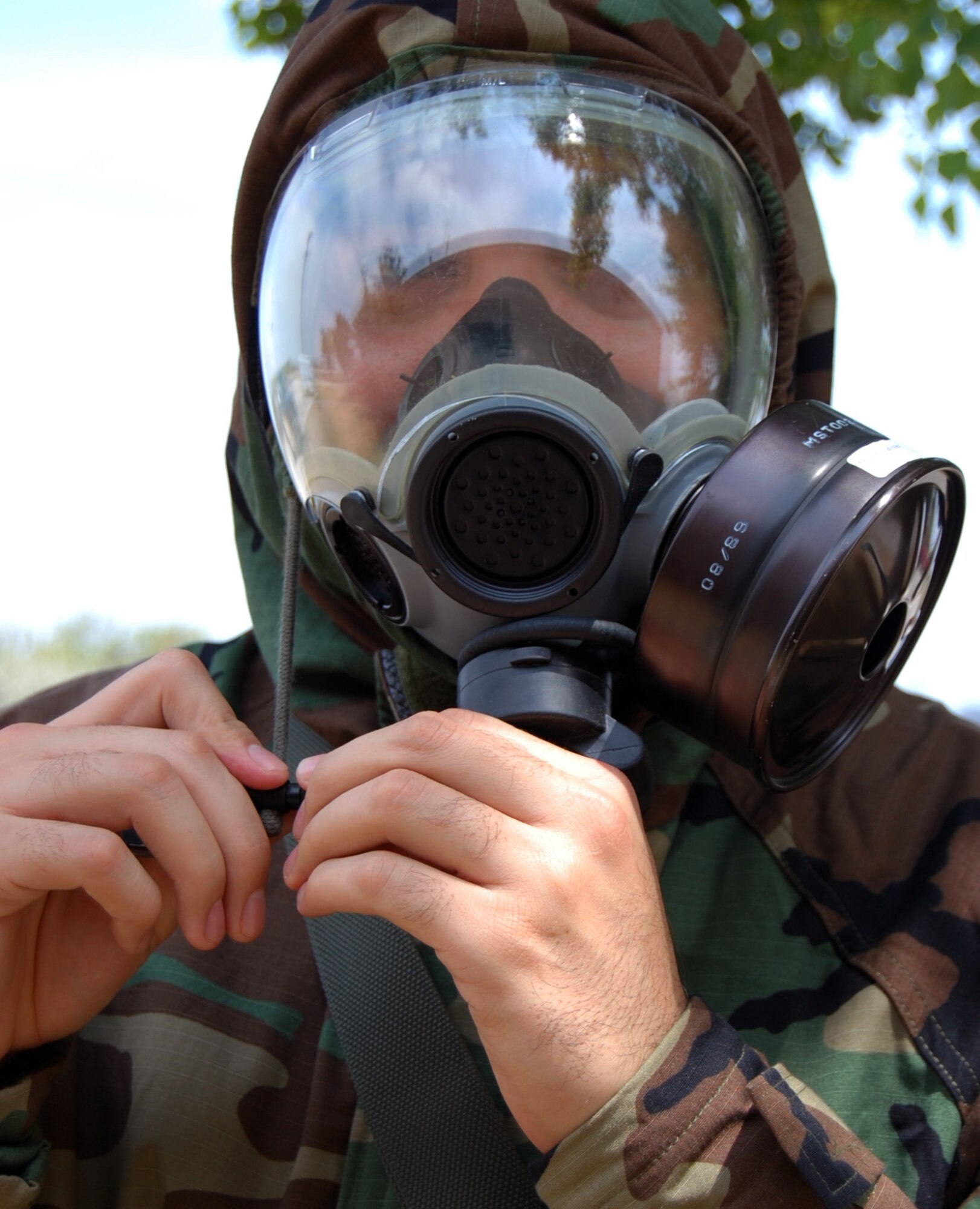 LAUGHLIN AIR FORCE BASE, Texas – Staff Sgt. Cesar Torres, 47th Flying Training Wing command section administration, tightens the draw stings on the hood of his chemical warfare suit here Aug. 11. Every Airman is required to attend yearly Chemical Biological Radiological Nuclear and Explosive training, including Post Attack Reconnaissance Sweeps. The primary mission of the readiness flight here is to ensure Laughlin is prepared for any emergency management situation and to ensure all Airmen are prepared for wartime missions. (U.S. Air Force photo by Airman 1st Class Sara Csurilla) 