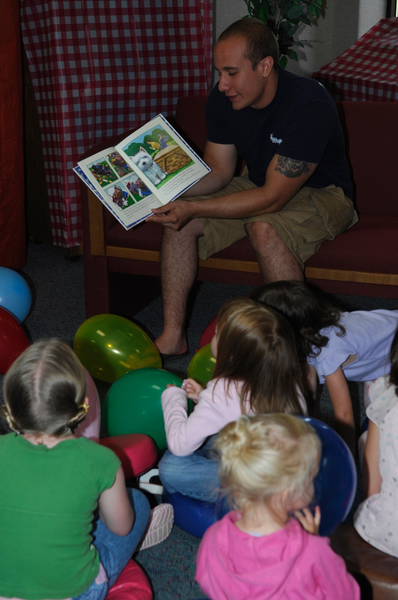 MINOT AIR FORCE BASE, N.D. – Staff Sgt. Anthony Horvath, 5th Aircraft Maintenance Squadron weapons load team member, reads a book to a group of children during the Summer Reading Program wrap-up celebration held at the base library here Aug. 9. This year the base library had a total of 304 children and adults enjoy the summer-long program. (U.S. Air Force photo by Tech. Sgt. Marelise Wood)