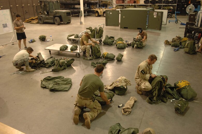 Pararescuemen from the 48th Rescue Squadron prepare their equipment for night operations here August 5.  (U.S. Air Force photo by Senior Airman Alesia Goosic)